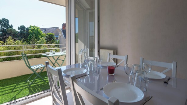 A dining area with a table set for four, including plates, cutlery, and wine glasses. - Le Filage - Balcon - Wifi (Laval)