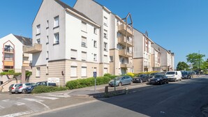 A multi-story residential building with balconies and a parking area. - Le Filage - Balcon - Wifi (Laval)