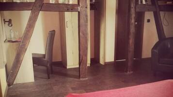 Una habitación con techo de madera, alfombra roja y una silla.