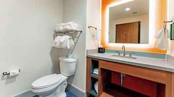 A bathroom with a toilet, a sink, a mirror, and a towel rack.