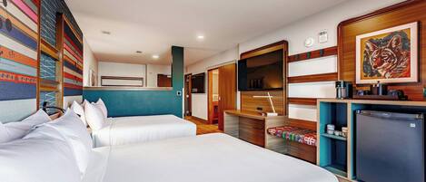Een hotelkamer met twee bedden, een kitchenette, een badkamer en een groot raam.