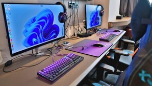 Um computador montado com dois monitores, teclado e rato sobre uma mesa.
