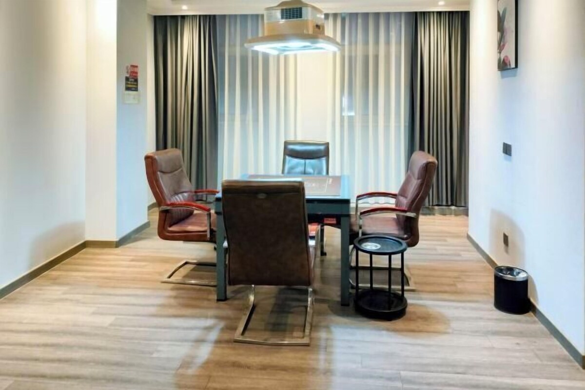 A conference room with a table, chairs, and a small side table.