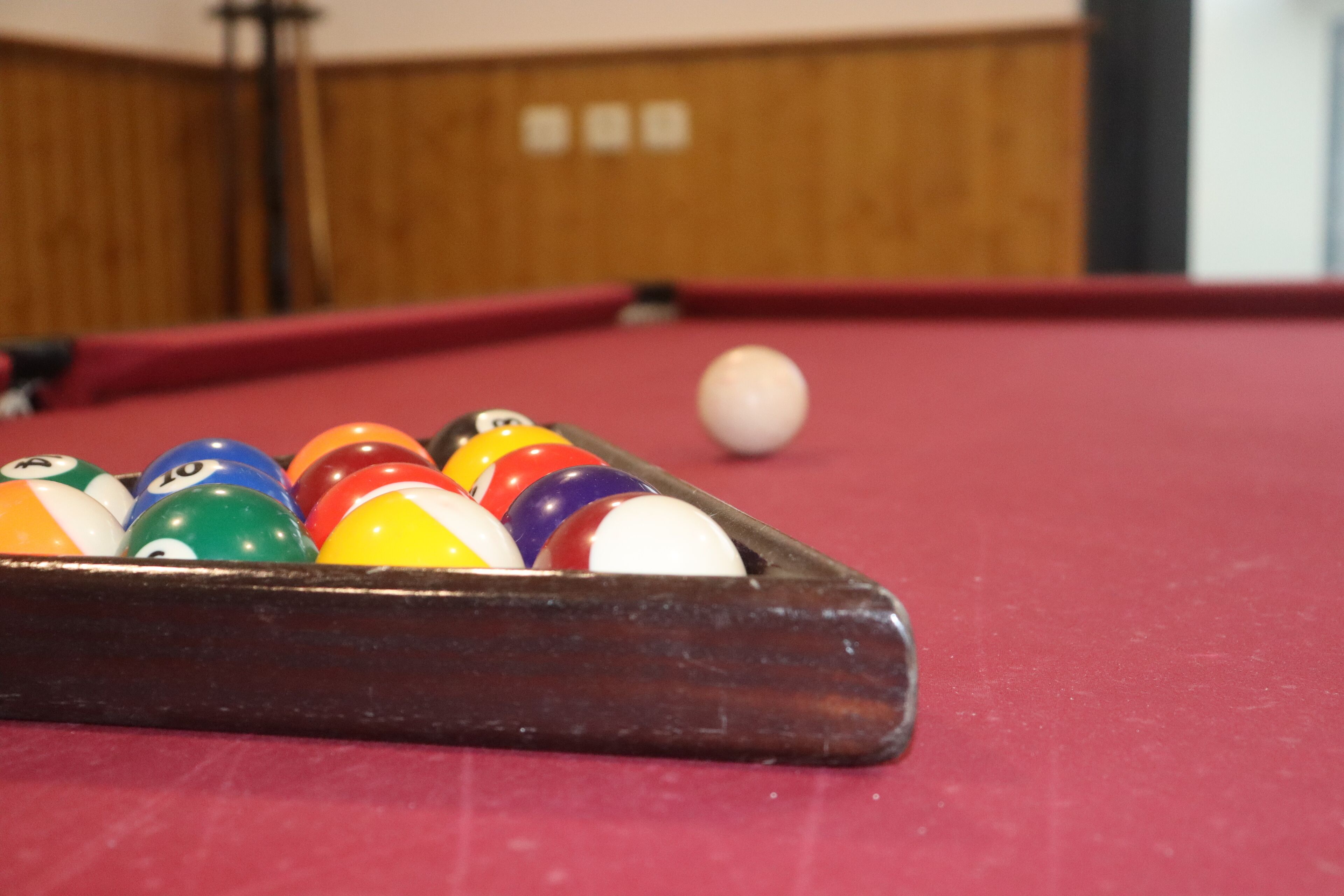 A close-up of a pool table with a set of billiard balls.