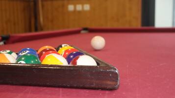 A close-up of a pool table with a set of billiard balls.