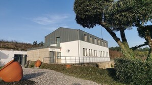 Un bâtiment moderne doté d’un toit plat, de grandes fenêtres et d’une façade en pierre.