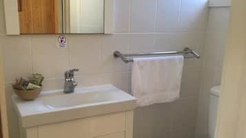 Chuveiro, toalhas de banho, sabonete, shampoo