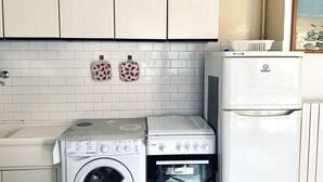 A compact kitchen with a washing machine, a stove, and a refrigerator. - RM08 - Senigallia, two-room apartment facing the sea (Senigallia)