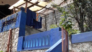 Een trap met blauwe leuningen die naar een gebouw met een stenen muur leidt.