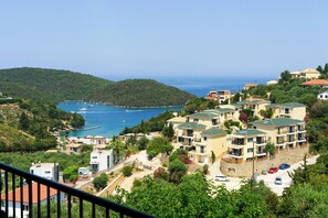 A coastal residential area with multiple two-story buildings, a marina with boats, and a clear view of the sea. - The Dandy Horizon (Igoumenitsa)