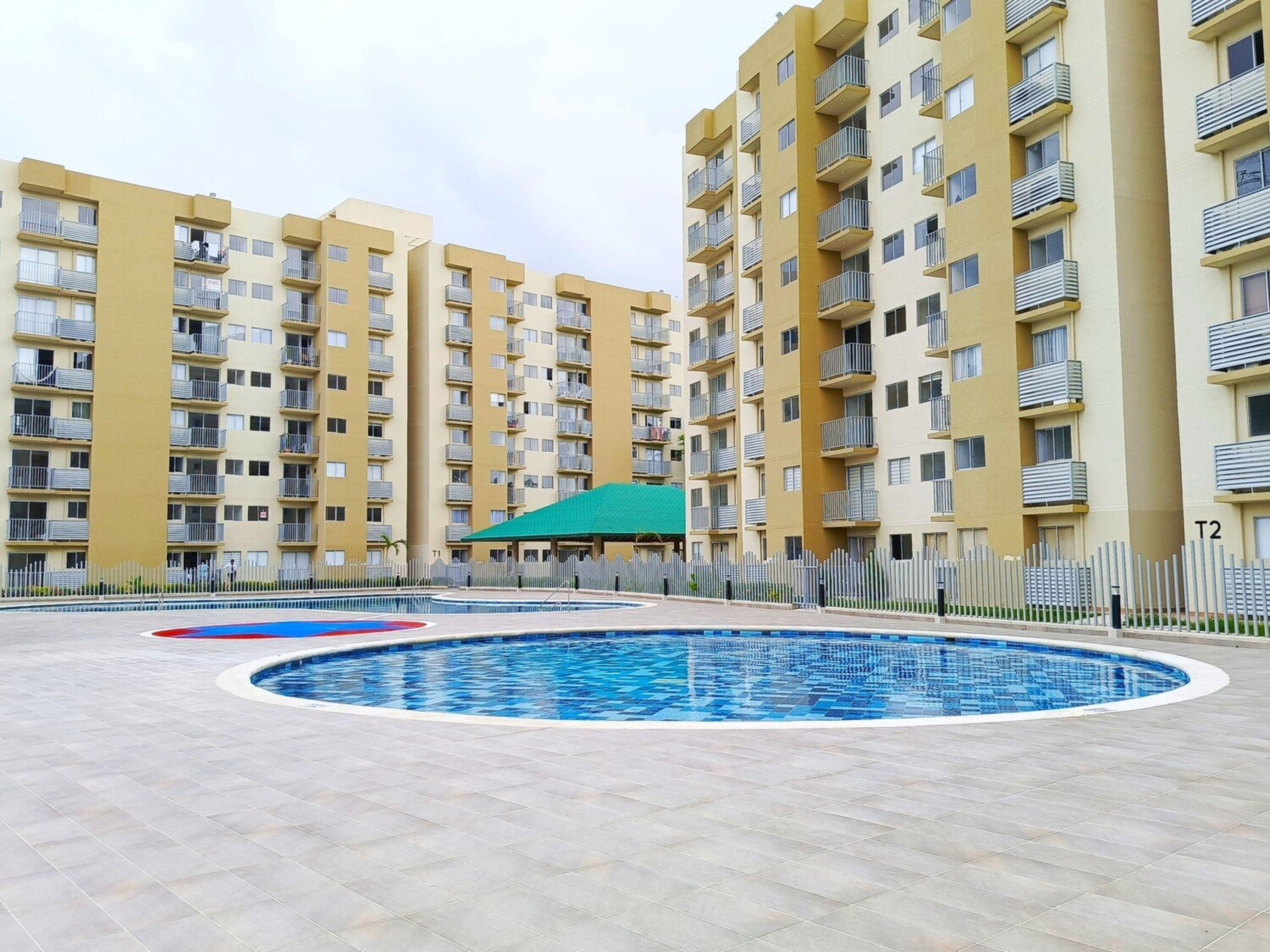 A residential building with multiple balconies and a swimming pool area.