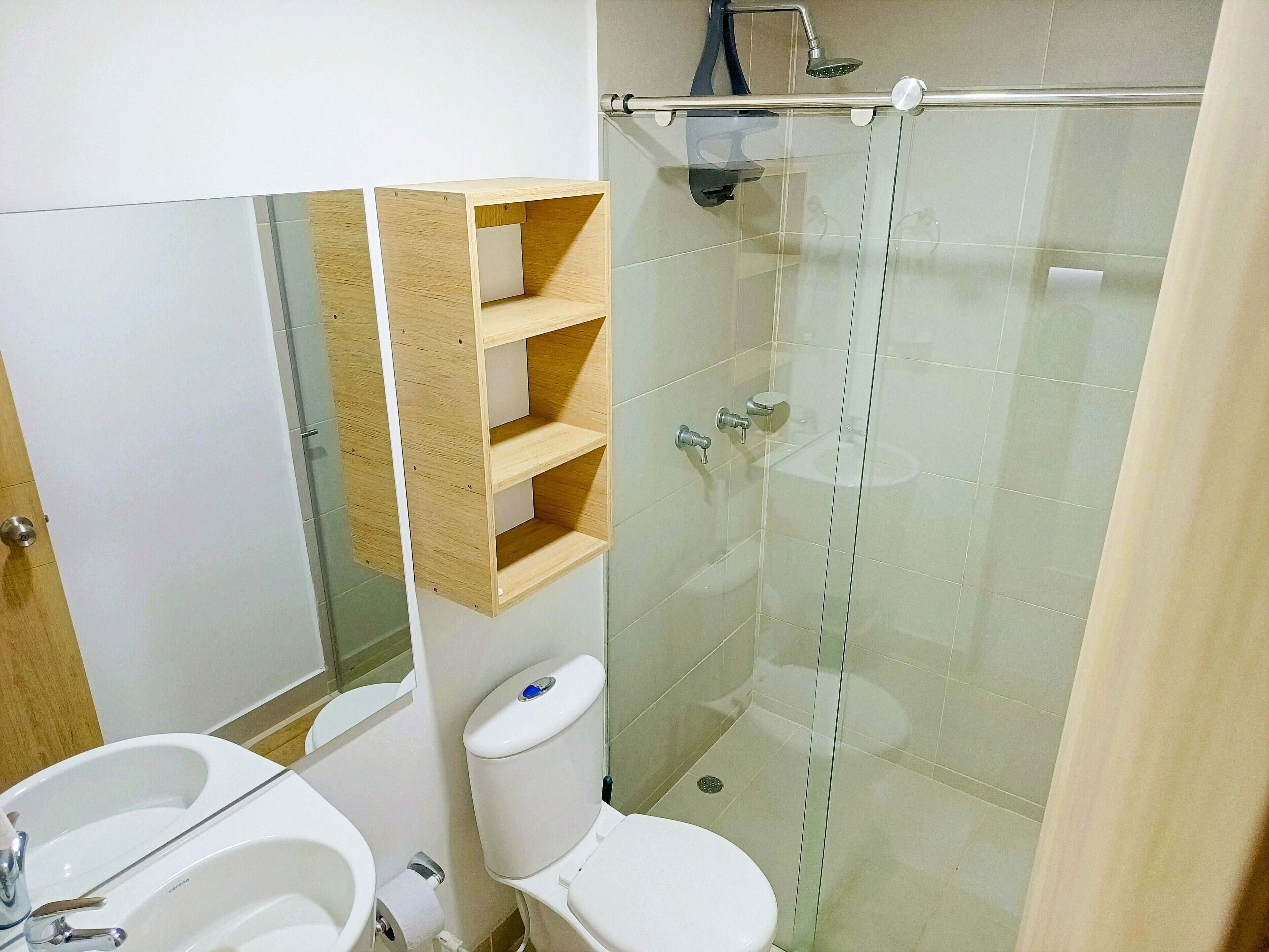 Une salle de bain avec une douche à parois de verre, des toilettes et un lavabo.