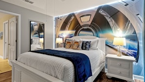 Una camera da letto con soffitto a forma di arco, un letto con testiera bianca, due comodini con lampade e un grande specchio.