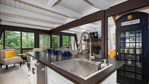 A kitchen with a large island, a built-in sink, and a telephone booth. - Country Squire Cabin - private 180 degree mountain views! (Basye)