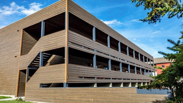 Een modern gebouw met een uniek architectonisch ontwerp, met meerdere verdiepingen en een opvallende trap.