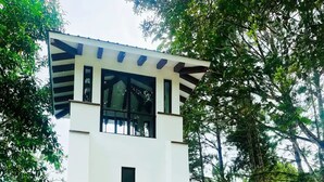 A two-story building with a white exterior, a brown door, and large windows. - Casa de Verano in Valle Bonito

 (Provincia de Panamá Oeste)