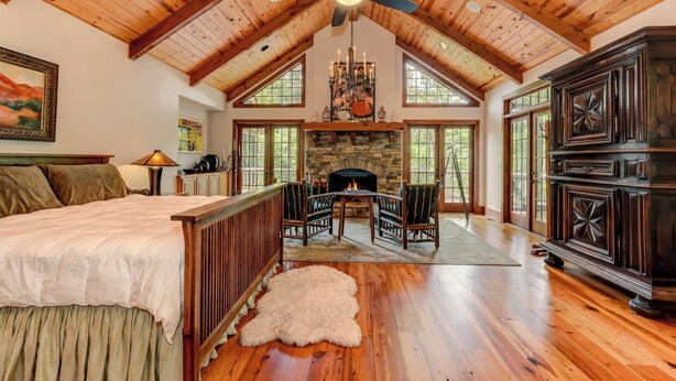 A spacious room with a high ceiling, a fireplace, wooden flooring, and a large window. - Plummer Lodge・Big Canoe・Theater・Game Room・Chef's Kitchen (Dawsonville)