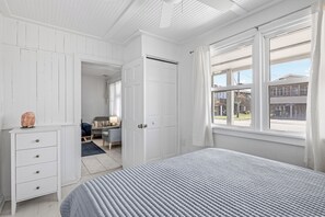 Un dormitorio con cama, cómoda y ventana con vistas al exterior.