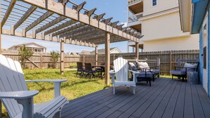A wooden deck with Adirondack chairs and a pergola. - Lunar Tide: Pet Friendly, Oceanside, Close to Beach and Avalon Pier (Kill Devil Hills)