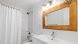 Une salle de bain moderne équipée d’une douche, de toilettes, d’un lavabo et d’un meuble-vasque.