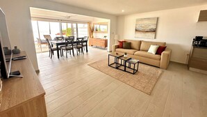 A spacious living area with a sofa, coffee table, and dining table. - GREAT VIEW Beautiful One bedroom on the beach nearly Red Bay Beach  (SAINT MARTIN)