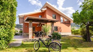 A two-story house with a balcony, a covered patio, and a bicycle parked outside. - Andrea and Carolina Domus (Castiglione Di Sicilia)