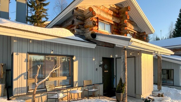 A log cabin with a covered patio, large windows, and a snow-covered ground. - Rukaköngäs 27 by Interhome (Kuusamo)