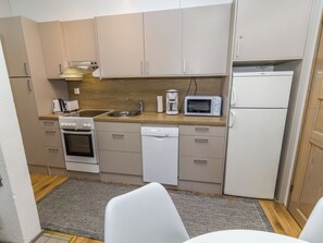 A compact kitchenette with a built-in oven, microwave, coffee maker, and a sink. - Rukaköngäs 27 by Interhome (Kuusamo)