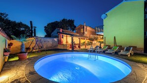 Una piscina amb gandules i una zona de terrassa.