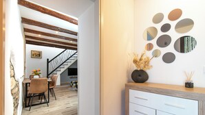 Un interior modern amb zona de menjador, escala i decoració a les parets.