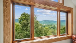 A window with a view of a forested landscape. - Modest condo with access to pool and hot tub B10 (Killington)