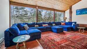A modern living room with a large sectional sofa, a glass coffee table, and a patterned rug. - 3 Bedroom Pet Friendly with Hot Tub Birch Beauty (Killington)