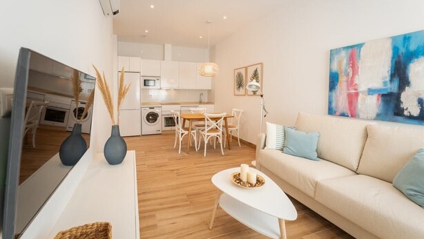 A modern apartment with a living room, dining area, and kitchen.