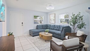 A modern living room with a sectional sofa, a coffee table, and a potted plant. - Entire Home: 4 Blocks to Ocean-Jacksonville Beach (Jacksonville Beach)