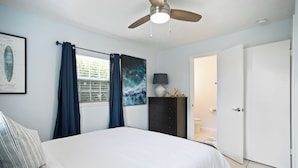 A bedroom with a bed, a ceiling fan, a window with curtains, a dresser, a framed picture, and a door. - Entire Home: 4 Blocks to Ocean-Jacksonville Beach (Jacksonville Beach)