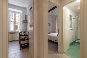 Una cocina compacta con estufa, repisas y una ventana.