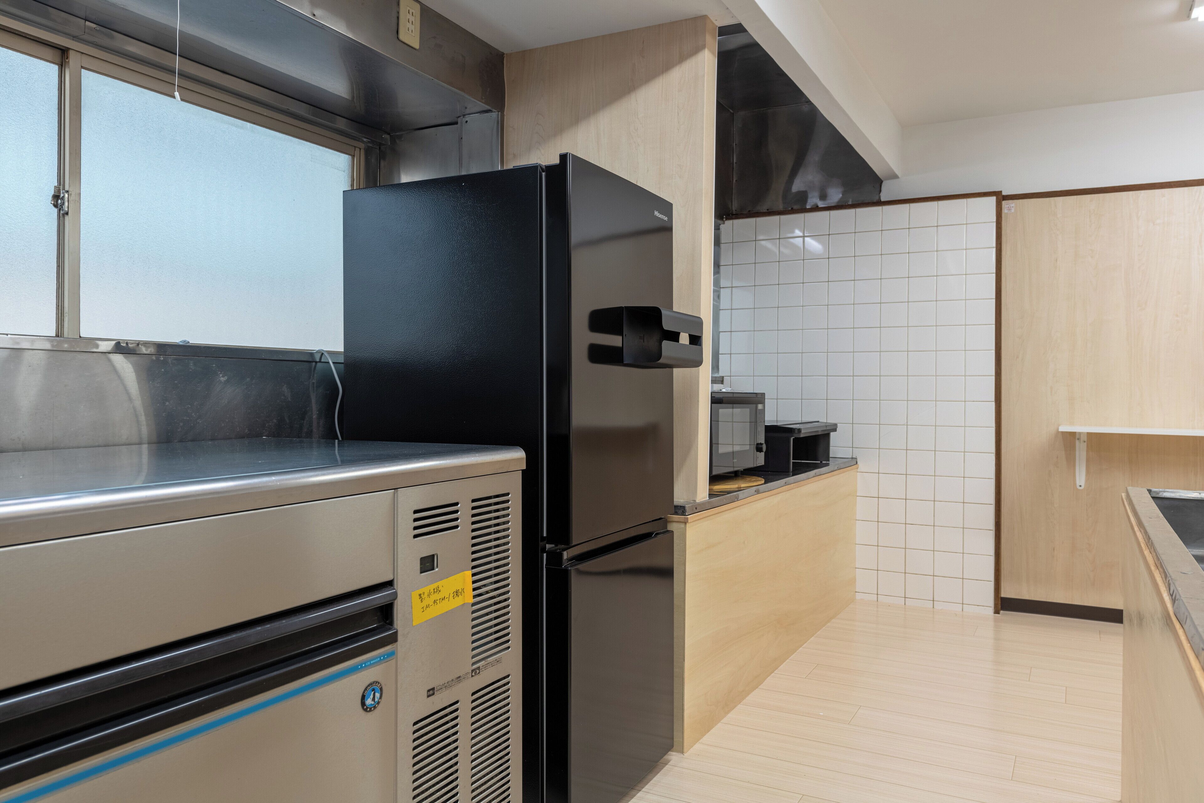 A modern kitchen with stainless steel appliances, a wooden countertop, and white tiled backsplash.
