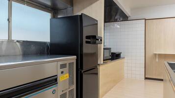 A modern kitchen with stainless steel appliances, a wooden countertop, and white tiled backsplash.