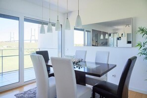 Enjoy meals in this dining area with a table for four, pendant lights, and a large mirror.