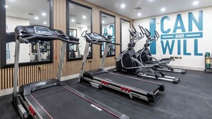 A gym with treadmills, ellipticals, and a motivational wall saying "I CAN AND WILL". - Palm Tree House | Namaste (Greater London)