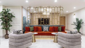 A modern living room with a sofa set, two side tables, and decorative plants. - Palm Tree House | Namaste (Greater London)