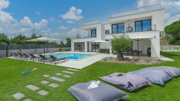 A modern two-story house with a swimming pool, outdoor seating, and a well-maintained lawn. - 78 (Medulin)