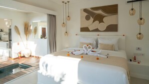 A hotel room with a large bed, a painting on the wall, and a water feature in the corner. - Villa Lior (Tabanan)