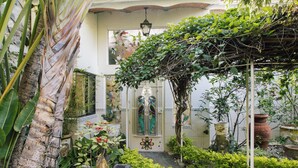 Un rigoglioso giardino con diverse piante e un portale decorativo.