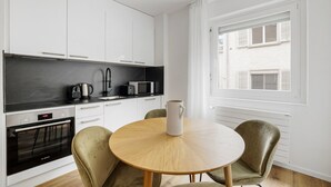 A modern kitchen with white cabinets, a Bosch oven, a microwave, and a coffee maker on the counter.