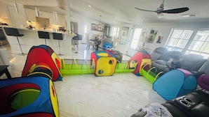 A spacious living area with a kitchen in the background, a dining table, and colorful play tents. - Cozy 4-bedroom house in welcoming Longs with WiFi, AC (Longs)