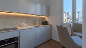 Una cocina moderna con horno integrado, cafetera y pileta.