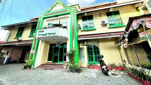 A two-story building with a sign reading "Hotel Tirtonadi Permai."
