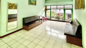 A waiting area with a bench, a small table, and a window with a view of the outside.