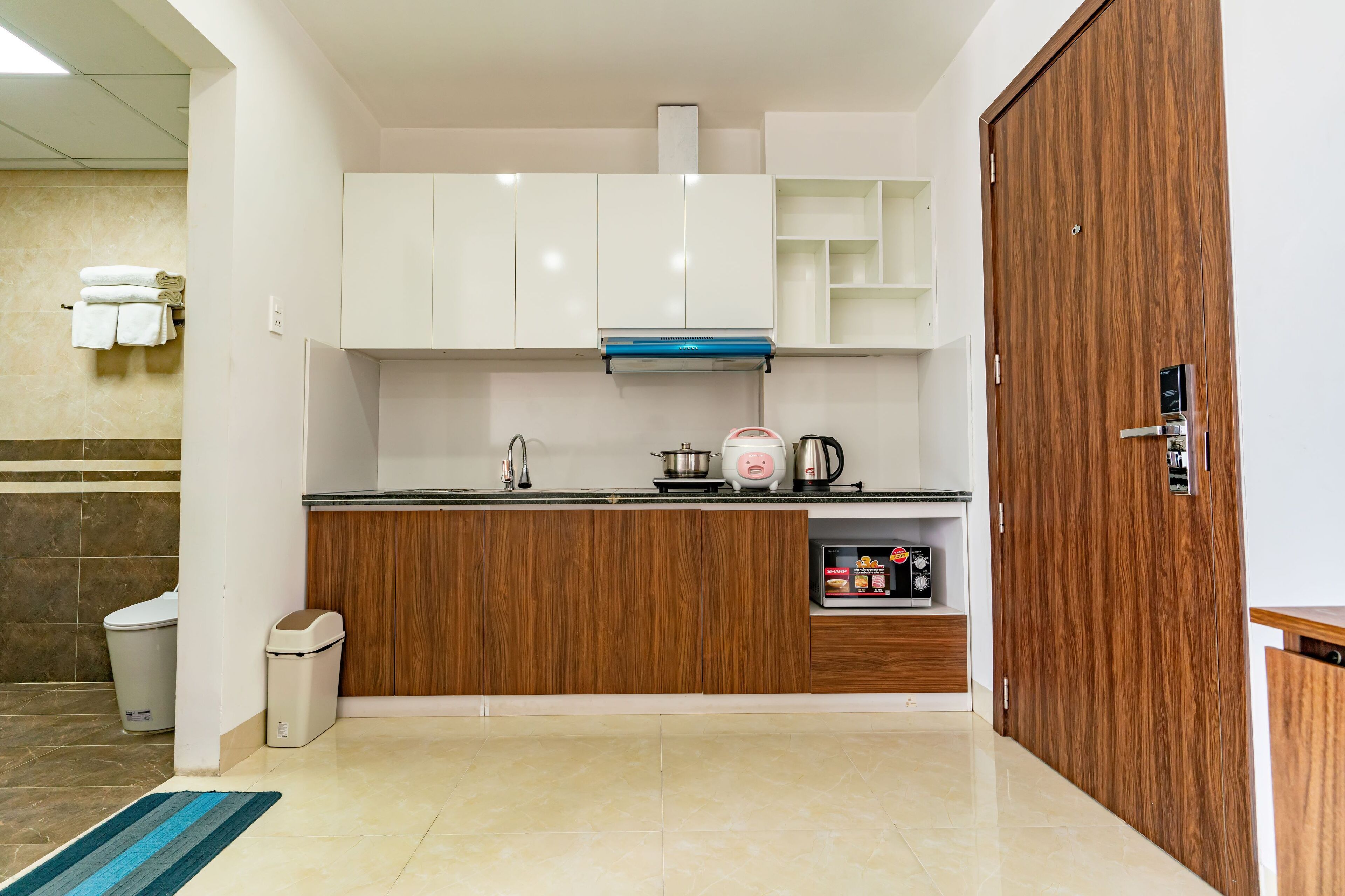 A modern kitchen with white cabinets, a wooden countertop, and a built-in oven.